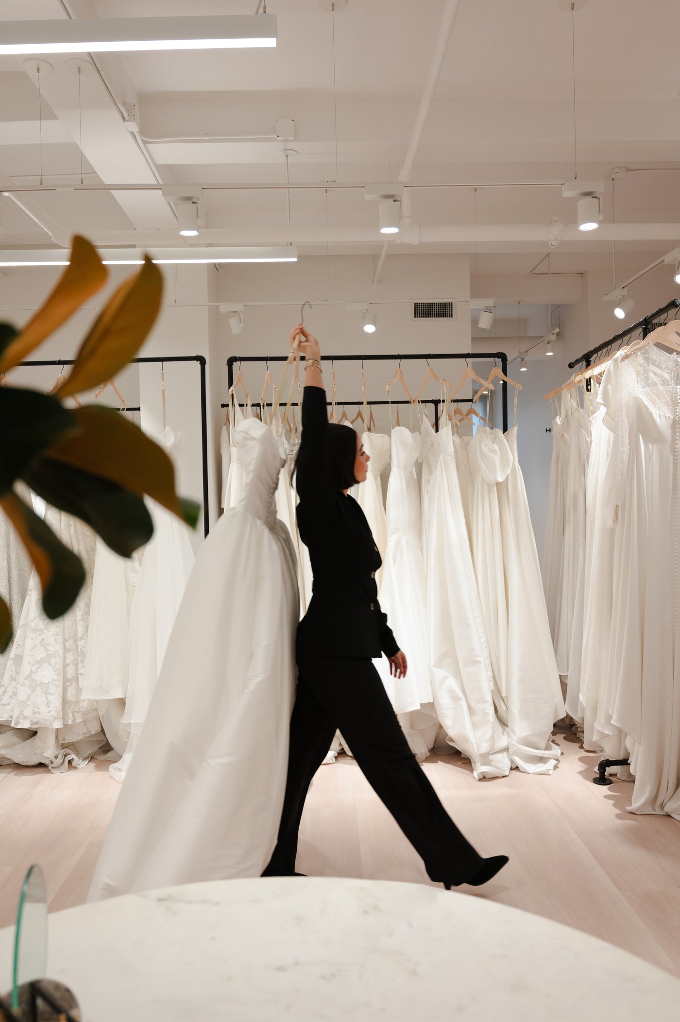 Bridal Consultant in Shop holding gown.